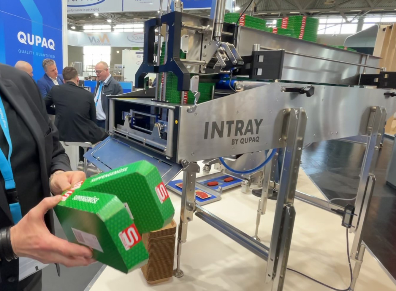 The QUPAQ Smart Tool – Flex was demonstrated on an INTRAY Smart Buffer at Anuga FoodTec 24. If you notice the cardboard trays on the picture – they have no lips or edges, why a normal screw denester will not work with these trays. With the QUPAQ Smart Tool – Flex, you can use many different tray types on the same line and equipment, with a standard tool changeover.