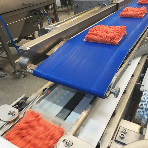 Meat being loaded into trays